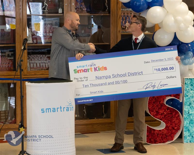 Smart rain giving a school donations which is just one of many companies that donates to schools